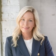 A woman in a suit poses for the camera.